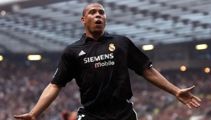 Camisa reserva retrô oficial do Real Madrid da temporada 2002-2003. A camisa é preta e branca e apresenta o logotipo do Real Madrid bordado e o emblema da Adidas. Foi usada pelos jogadores do Real Madrid durante a temporada de La Liga de 2002-2003, quando o clube conquistou o título.